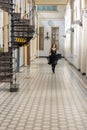 Beautiful girl in black dress running in hall checkered floor Royalty Free Stock Photo