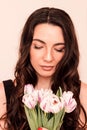 Beautiful girl in a black dress with tulips in her hands