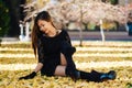 Beautiful girl in black vintage dress and hand glove. Woman in retro dress playing in the park with ginko leafs. Red lips Royalty Free Stock Photo