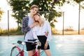 Beautiful girl with blond hair dreamily closing her eyes while standing with smiling boy that looking in camera in park Royalty Free Stock Photo