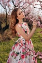 beautiful girl with blond hair in elegant clothes posing in blooming peach garden Royalty Free Stock Photo