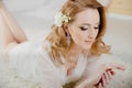 Beautiful girl with blond hair is lying on the floor. The bride is lying down looking at her wedding ring and smiling Royalty Free Stock Photo