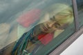 Beautiful girl with blonde hair taking a nap in the car on a rainy day