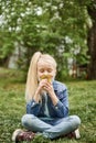 Beautiful girl with blonde hair took off her mask and sniffs dandelions, spring is coming