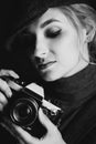 Beautiful girl blonde photographer in a strict suit and a cappie is holding an old retro camera in her hands Royalty Free Stock Photo