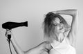 Beautiful girl blow drying her hair, hairdryer. Young woman with drying hair with hair dry machine after showering. Royalty Free Stock Photo