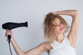 Beautiful girl blow drying her hair, hairdryer. Young woman with drying hair with hair dry machine after showering. Royalty Free Stock Photo