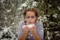 Beautiful girl blowing snow off her hands. Outdoor winter portrait. Royalty Free Stock Photo