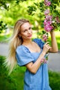 Beautiful girl in a blue dress in a blooming pink Apple garden. Girl and Sakura concept. Young woman enjoying sunny day in park Royalty Free Stock Photo