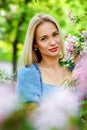 Beautiful girl in a blue dress in a blooming pink Apple garden. Girl and Sakura concept. Young woman enjoying sunny day in park Royalty Free Stock Photo