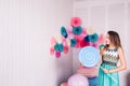 Beautiful girl in blue dress hold in hand huge candy in studio with decor of macaroons. Copy space.