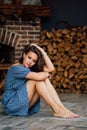 Beautiful girl in blue dress sit barefoot on floor Royalty Free Stock Photo