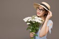 Beautiful girl in a blue dress with white flowers in her hands on a gray background. Royalty Free Stock Photo