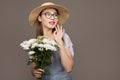 Beautiful girl in a blue dress with white flowers in her hands on a gray background. Young happy woman holding a basket with Royalty Free Stock Photo