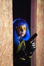 Beautiful girl with blue hair holding gun in strikeball location background Royalty Free Stock Photo