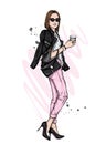 Beautiful girl with a bob hairstyle in a stylish jacket, jeans and high-heeled shoes. Woman with a glass of coffee. Fashion.