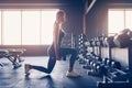 Beautiful girl doing lunges exercise with dumbbells in gym Royalty Free Stock Photo