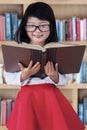 Beautiful girl with book in library Royalty Free Stock Photo