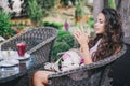 Beautiful girl with a bouquet of peonies sitting in a restaurant Royalty Free Stock Photo