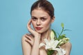 Beautiful girl with a bouquet of white flowers on a blue background cropped view naked shoulders portrait