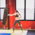 Beautiful girl boxing against punching bag (intentionally blurred) Royalty Free Stock Photo