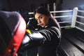 A beautiful girl in boxing gloves hits her paws in the ring. Sexy woman is training in the gym. Beautiful brunette is Royalty Free Stock Photo