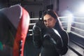 A beautiful girl in boxing gloves hits her paws in the ring. Sexy woman is training in the gym. Beautiful brunette is engaged in Royalty Free Stock Photo