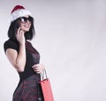 Beautiful girl in braces cap santa , adult, holiday, hat, female, christmas, young, santa, cap, clapackage for shopping smartphone Royalty Free Stock Photo