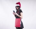 beautiful girl in braces cap santa , package for shopping smartphone Royalty Free Stock Photo