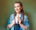 Beautiful girl with braids sitting in a cafe and drinking a milkshake, smiling at the camera Royalty Free Stock Photo