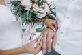 Beautiful girl bride in wedding white dress puts on the groom`s finger the wedding gold ring. Royalty Free Stock Photo