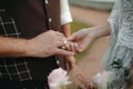 Beautiful girl bride in wedding white dress puts on the groom`s finger the wedding gold ring Royalty Free Stock Photo