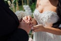 Beautiful girl bride in wedding white dress puts on the groom`s finger the wedding gold ring Royalty Free Stock Photo