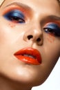 Beautiful girl with bright colored makeup and orange lips. Beauty face. Royalty Free Stock Photo