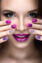 Beautiful girl with a bright evening make-up and purple manicure with rhinestones. Nail design. Beauty face.
