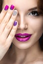 Beautiful girl with a bright evening make-up and purple manicure with rhinestones. Nail design. Beauty face. Royalty Free Stock Photo