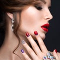 Beautiful girl with a bright evening make-up and red manicure with rhinestones. Nail design. Beauty face. Royalty Free Stock Photo