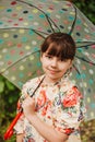 A beautiful girl in a bright raincoat walks during the rain under an umbrella. Soft focus Royalty Free Stock Photo