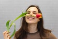 Beautiful girl in the brown dress with flowers tulips in hands on a light background Royalty Free Stock Photo