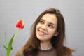 Beautiful girl in the brown dress with flowers tulips in hands on a light background Royalty Free Stock Photo