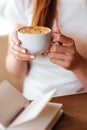 Capuccino in hands of young girl Royalty Free Stock Photo