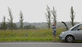 Beautiful girl calling cellphone near her broken car on a country road