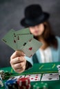 beautiful girl came to the night casino to play poker at a wide green table. a woman in a hat