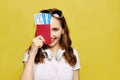 A beautiful girl in casual clothes holds a passport and airline tickets covering half her face Royalty Free Stock Photo