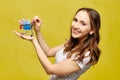 Beautiful girl in casual clothes holds a shopping trolley in the palm of her hand with bank credit cards Royalty Free Stock Photo