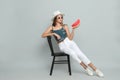 Beautiful girl on chair with watermelon against grey background Royalty Free Stock Photo