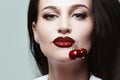 Beautiful girl with cherries in her mouth