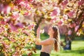 Beautiful girl in cherry blossom garden on a spring day