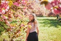 Beautiful girl in cherry blossom garden on a spring day