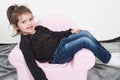 Girl child sitting on a pink children seat